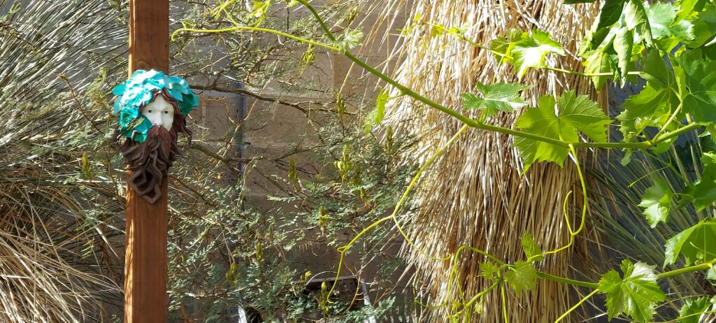 green man mask in a witch's garden